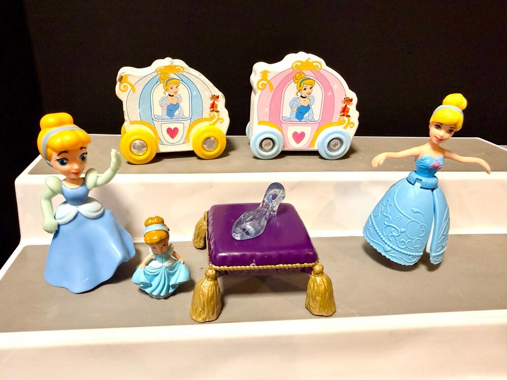 Disney's Cinderella toy figures, carriages, glass slipper on a cushioned stool